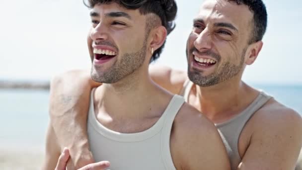 Zwei Männer Lächeln Selbstbewusst Und Umarmen Sich Strand — Stockvideo
