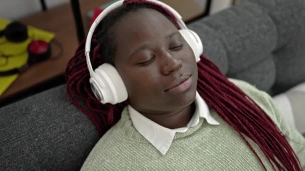 Afrikaanse Vrouw Met Gevlochten Haar Luisteren Naar Muziek Liggend Bank — Stockvideo