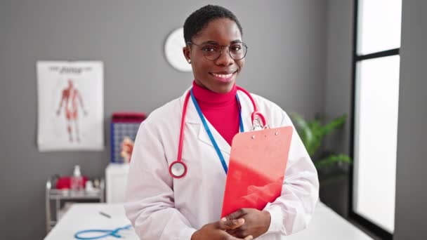 Africano Americano Mulher Médico Sorrindo Confiante Segurando Relatório Médico Clínica — Vídeo de Stock