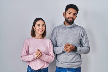 Genç İspanyol çift el ele tutuşmuş ve parmaklarını çapraz yapıp gülümsüyor rahat ve neşeli. Başarı ve iyimserlik 