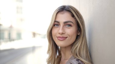 Sokakta kendine güvenen genç sarışın kadın gülümsüyor