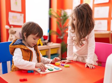 Anaokulunda masada oturmuş matematik oyunu oynayan sevimli kız ve oğlan.