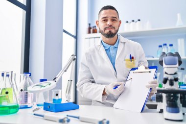 Laboratuvarda çalışan İspanyol bir adam elinde komik suratlı, boş bir pano şişiren yanakları tutuyor. Ağzı havayla şişer, havayı yakalar.. 