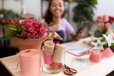 Young african american woman florist smiling confident using touchpad at flower shop