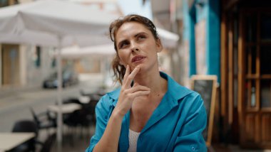 Sokakta şüpheli bir ifadeyle duran genç kadın.