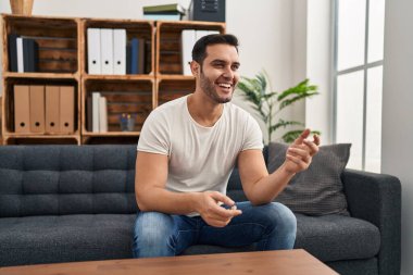 Psikoloji merkezindeki kanepede oturan Latin Amerikalı genç adam.