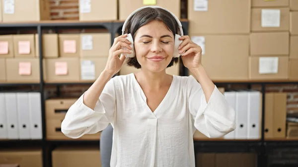 若い美しいですヒスパニック女性電子商取引労働者に耳を傾け音楽にオフィス — ストック写真
