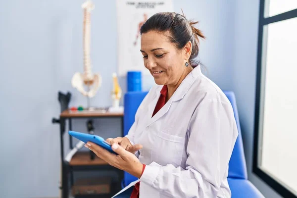 Middle Age Hispanic Woman Physiotherapist Using Touchpad Rehab Clinic — Stockfoto