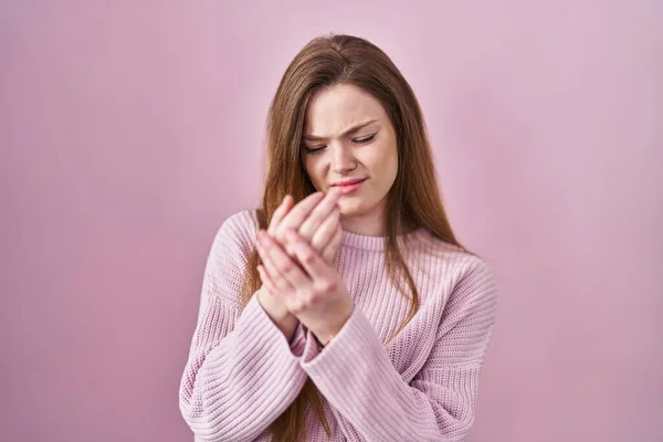 年轻的高加索女人站在粉红的背景上 手指头疼痛 关节炎 — 图库照片