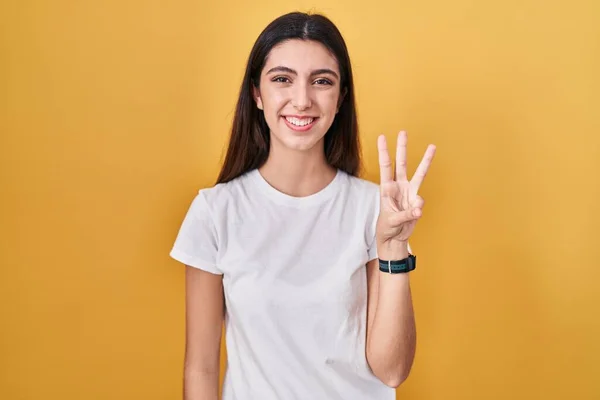Sarı Arka Planda Duran Genç Güzel Bir Kadın Numaralı Parmaklarıyla — Stok fotoğraf