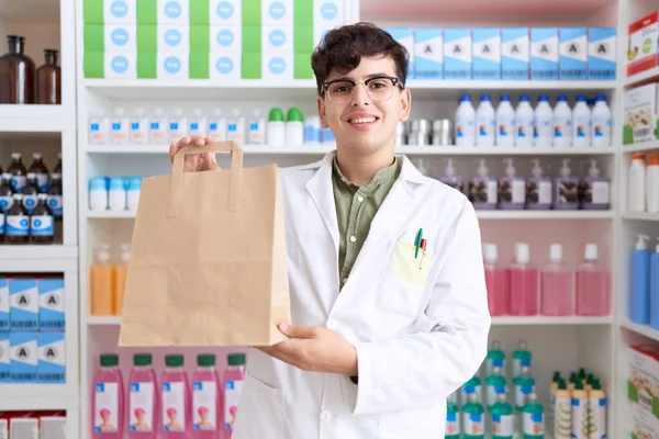 Non Binary Man Pharmacist Smiling Confident Holding Shopping Bag Pharmacy — Stok Foto