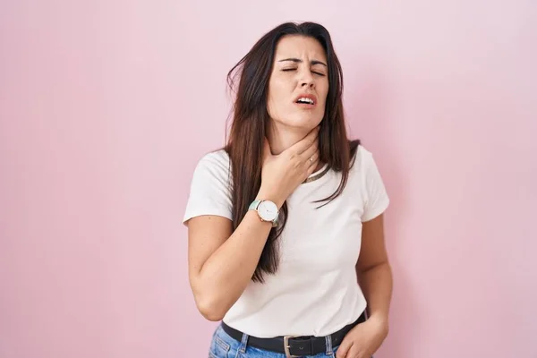 若いですブルネット女性立ち上のピンクの背景感動痛みを伴う首 痛みを伴う喉のためにインフルエンザ 雲と感染 — ストック写真