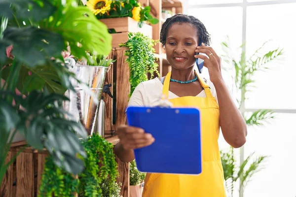 Middle Age African American Woman Florist Talking Smartphone Reading Document — Stock Photo, Image