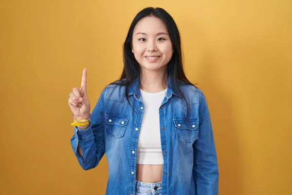 Young Asian Woman Standing Yellow Background Showing Pointing Finger Number — Stock Photo, Image