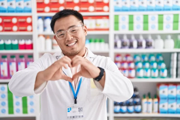 Jovem Chinês Trabalhando Farmácia Farmácia Sorrindo Amor Fazendo Forma Símbolo — Fotografia de Stock