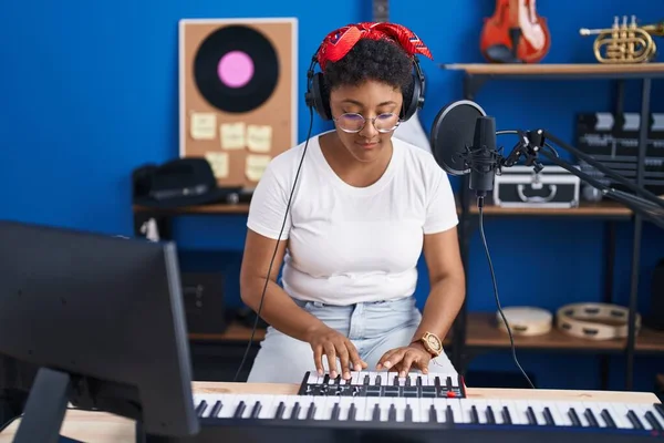 stock image African american woman musician playing piano at music studio