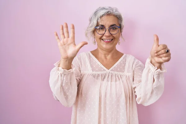 Pembe Arka Planda Duran Gri Saçlı Orta Yaşlı Kadın Altı — Stok fotoğraf