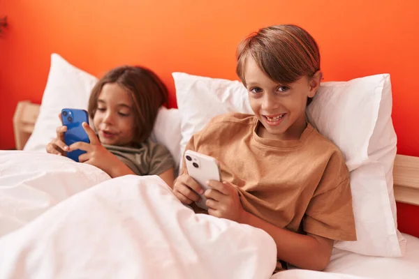 Adorables Chicos Usando Teléfono Inteligente Sentado Cama Dormitorio —  Fotos de Stock