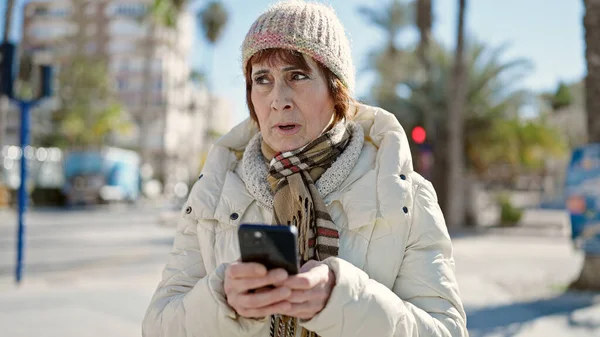 Ώριμη Ισπανόφωνη Γυναίκα Στέκεται Σοβαρή Έκφραση Χρησιμοποιώντας Smartphone Στο Δρόμο — Φωτογραφία Αρχείου