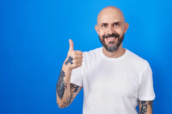 Spanyol Férfi Tetoválásokkal Kék Háttér Felett Boldog Hüvelykujjal Felemelt Kézzel — Stock Fotó