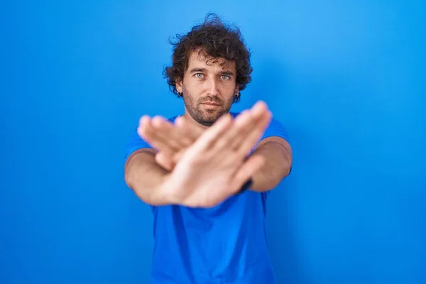 Ισπανόφωνος Νεαρός Άνδρας Στέκεται Πάνω Από Μπλε Φόντο Έκφραση Απόρριψης — Φωτογραφία Αρχείου