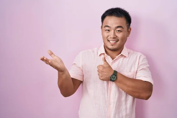 Chinese Young Man Standing Pink Background Showing Palm Hand Doing — Stock Photo, Image