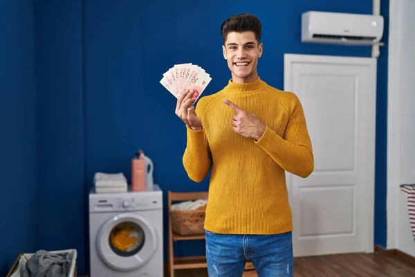 Jonge Spaanse Man Wasruimte Met Sjaaltjes Glimlachend Wijzend Met Hand — Stockfoto