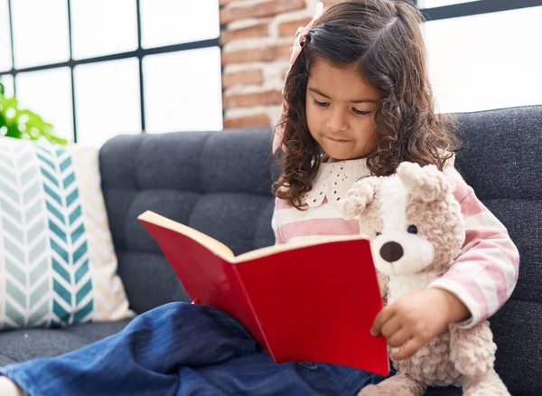 Adorable Hispanic Girl Reading Book Sitting Sofa Home — Foto Stock
