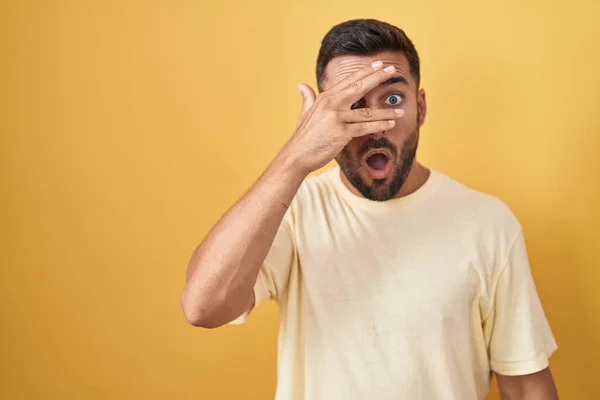 Schöner Hispanischer Mann Der Vor Gelbem Hintergrund Steht Und Schockiert — Stockfoto