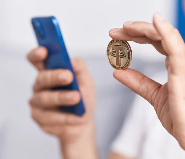 stock image Middle age man holding tether crypto currency using smartphone at home