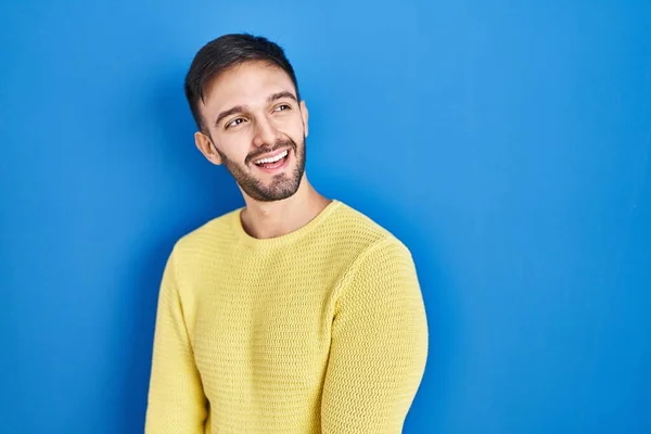 Homem Hispânico Sobre Fundo Azul Olhando Para Lado Com Sorriso — Fotografia de Stock