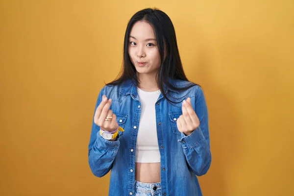 Jovem Mulher Asiática Sobre Fundo Amarelo Fazendo Gesto Dinheiro Com — Fotografia de Stock
