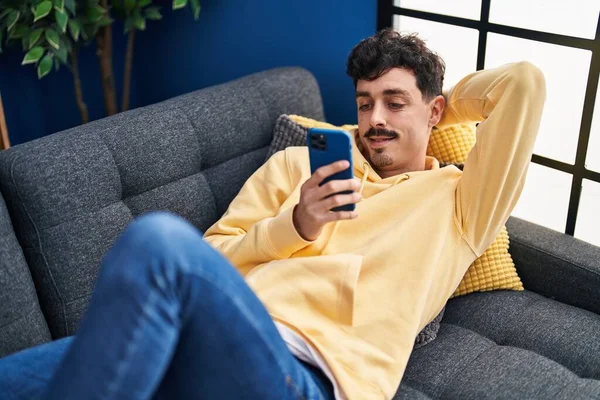 Young Caucasian Man Using Smartphone Lying Sofa Home — 스톡 사진