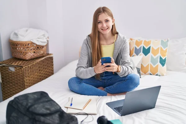 Beyaz Kadın Yatak Odasında Akıllı Telefon Kullanarak Gülümsüyor — Stok fotoğraf