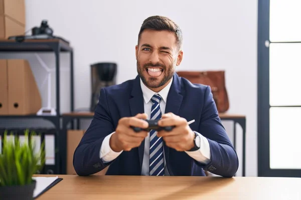 ハンサムなヒスパニック系男遊びビデオゲームでザ オフィスステッキング舌アウト幸せとともに面白い式 — ストック写真