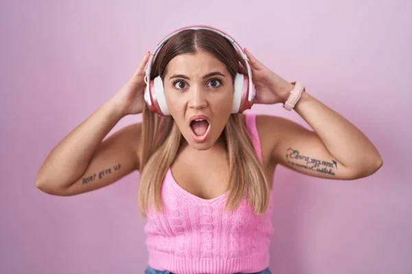 Young Blonde Woman Listening Music Using Headphones Crazy Scared Hands — Stock Photo, Image