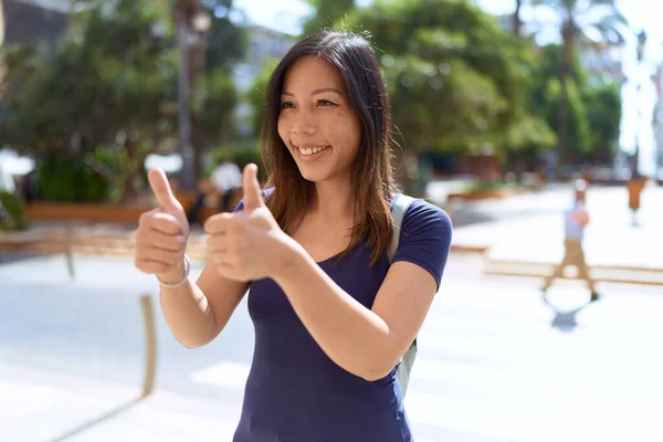 Genç Asyalı Kadın Gülümsüyor Kendine Güveni Tam Başparmağıyla Sokakları Imzalıyor — Stok fotoğraf
