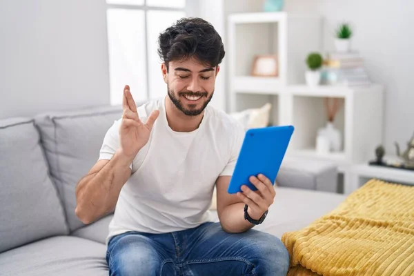 Hispanic Man Beard Using Touchpad Sitting Sofa Gesturing Finger Crossed — Stock Photo, Image