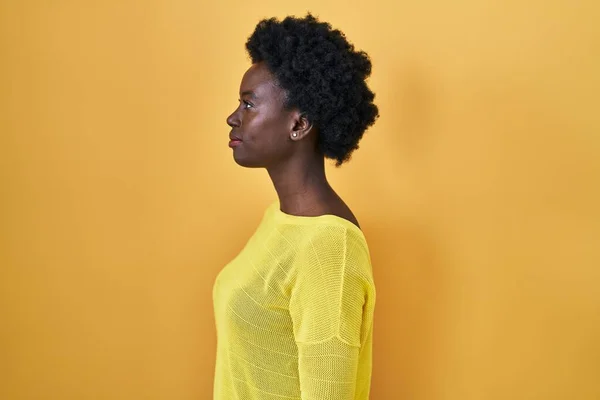 Afrikaanse Jonge Vrouw Staande Gele Studio Zoek Naar Kant Ontspannen — Stockfoto