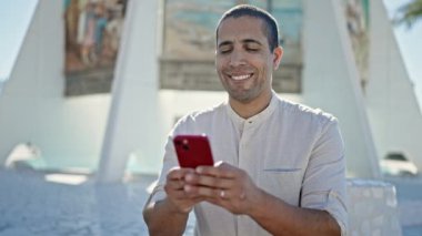 Sokakta akıllı telefon kullanan genç bir İspanyol.