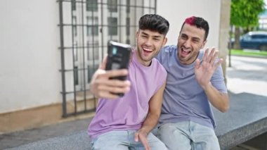 Two men couple smiling confident having video call at street