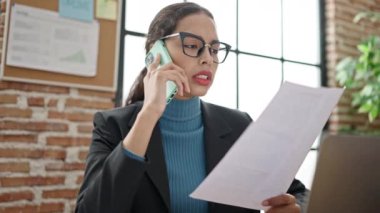 Ofisteki telefon okuma dökümanında konuşan genç, güzel İspanyol iş kadını.