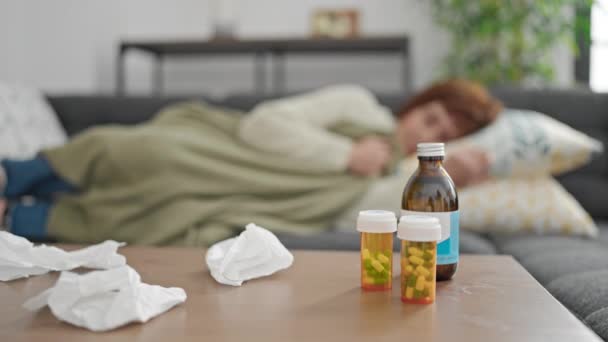 熟女ヒスパニック女性横たわっザソファ病気とともに組織と薬上のテーブルの上に自宅 — ストック動画