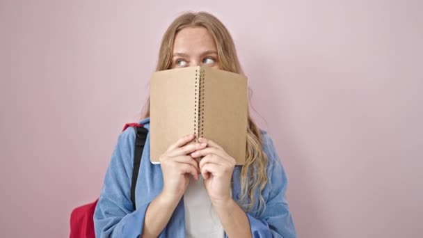 Mladá Blondýna Žena Student Pokrytí Úst Knihou Přes Izolované Růžové — Stock video