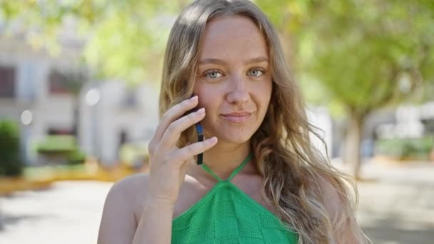 Mujer Rubia Joven Sonriendo Confiado Hablando Teléfono Inteligente Parque — Vídeo de stock