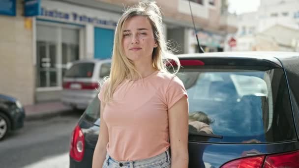 Νεαρή Ξανθιά Γυναίκα Που Κατέχει Νέα Άδεια Οδήγησης Στέκεται Αυτοκίνητο — Αρχείο Βίντεο
