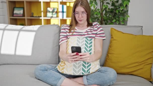 Junge Blonde Frau Sitzt Mit Ernstem Gesichtsausdruck Auf Sofa Und — Stockvideo