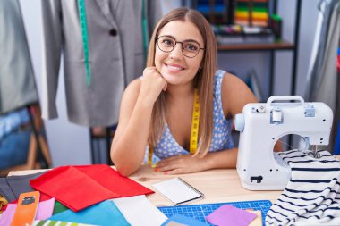 Genç, güzel İspanyol kadın terzi dükkanında kendine güvenen, gülümseyen.