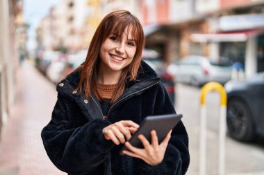 Sokakta dokunmatik ped kullanan kendine güvenen genç bir kadın.