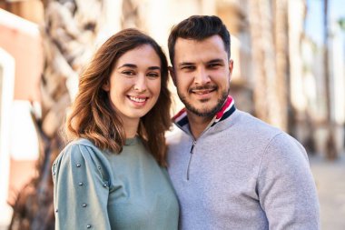 Man and woman smiling confident hugging each other standing at street